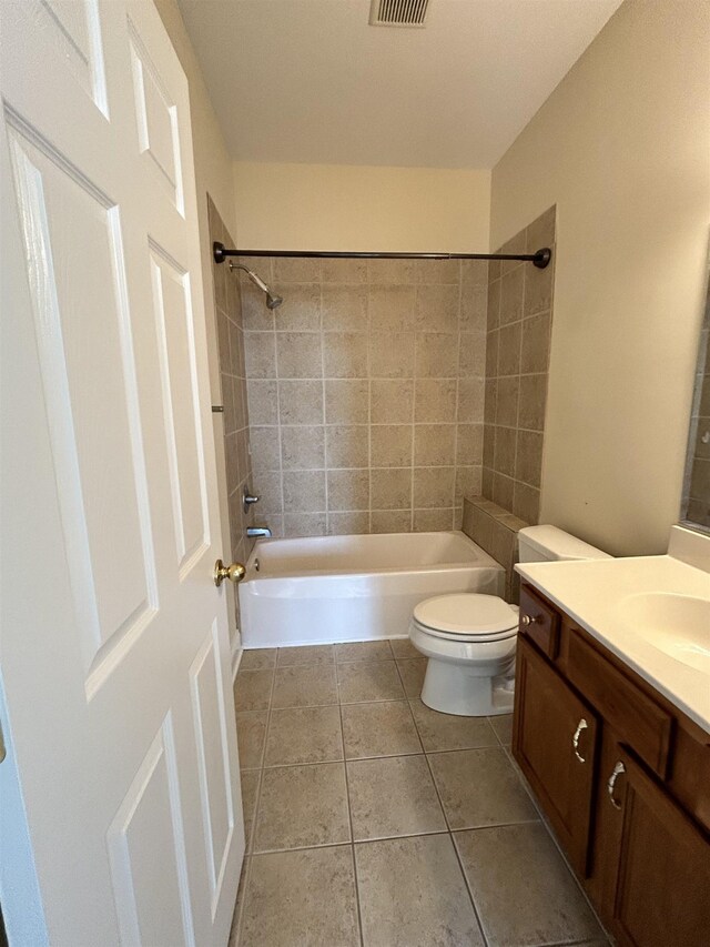 full bathroom with vanity, tile patterned flooring, tiled shower / bath combo, and toilet