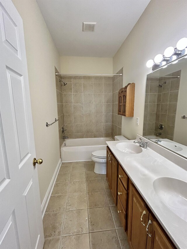 full bathroom featuring vanity, tile patterned floors, toilet, and tiled shower / bath