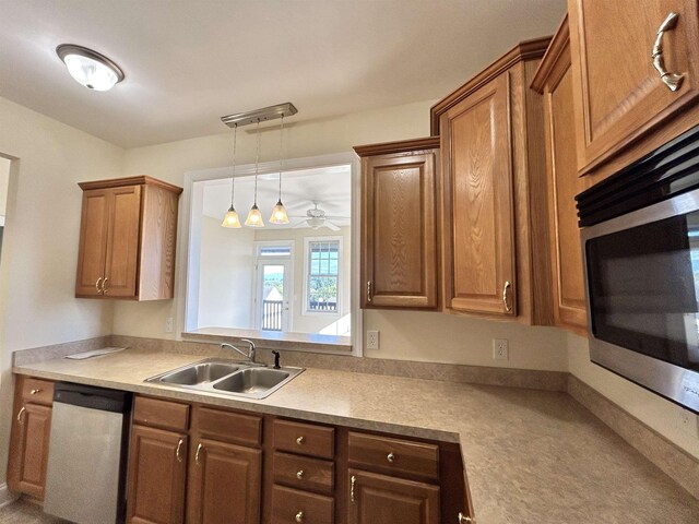 kitchen with appliances with stainless steel finishes, sink, and pendant lighting