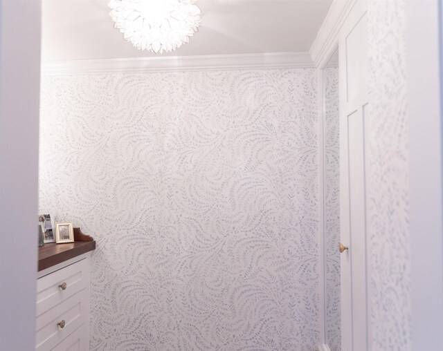 interior details featuring crown molding and an inviting chandelier