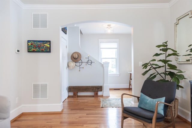 entryway featuring ornamental molding and light hardwood / wood-style flooring