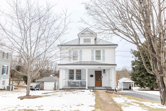 view of front facade with a garage, an outdoor structure, a porch, and central AC unit