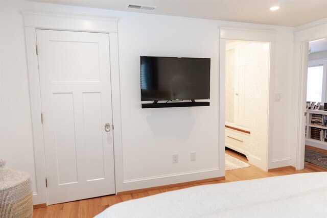 bedroom featuring connected bathroom and light wood-type flooring