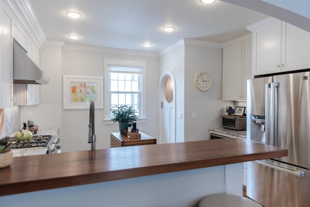 kitchen featuring white cabinetry, stainless steel refrigerator with ice dispenser, ornamental molding, and wood counters