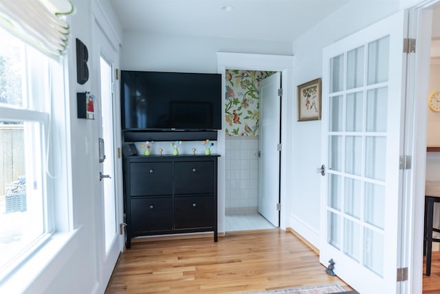 interior space with tile walls and light hardwood / wood-style floors