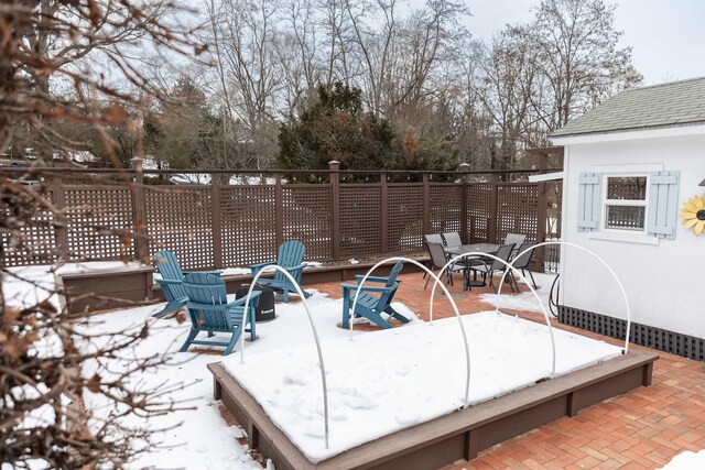 snow covered patio featuring an outdoor fire pit