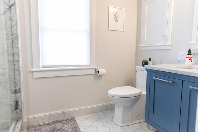 bathroom with vanity, a shower with door, and toilet