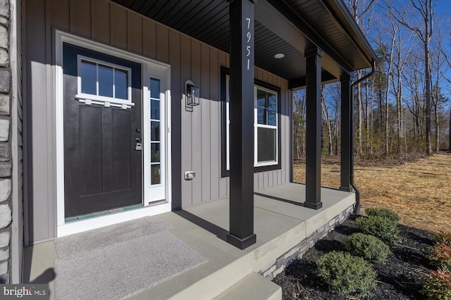 property entrance with covered porch and board and batten siding