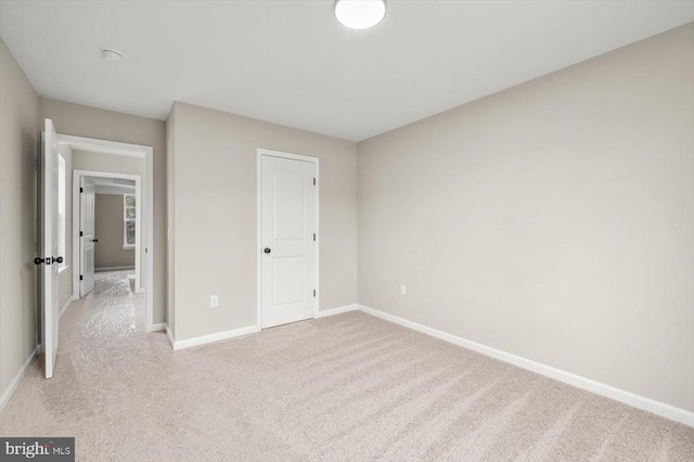 unfurnished bedroom with baseboards and light carpet