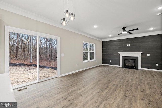 unfurnished living room featuring crown molding, a ceiling fan, wood finished floors, recessed lighting, and baseboards