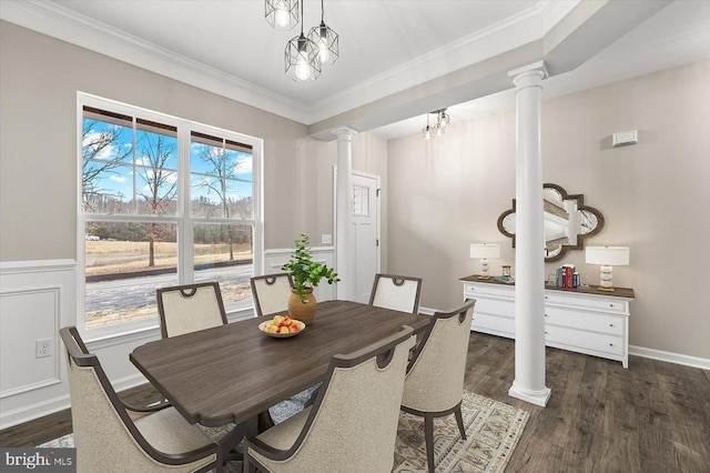 dining space featuring decorative columns, crown molding, dark wood-style floors, and a wainscoted wall