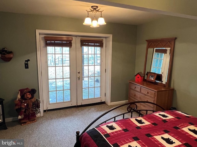 carpeted bedroom with an inviting chandelier, access to outside, french doors, and baseboards
