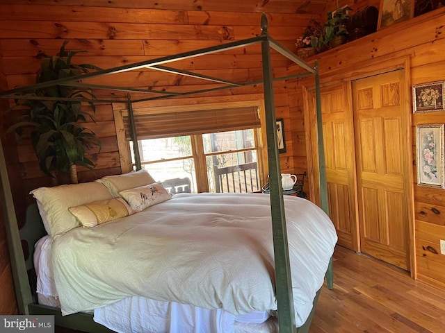 bedroom with wooden walls and wood finished floors