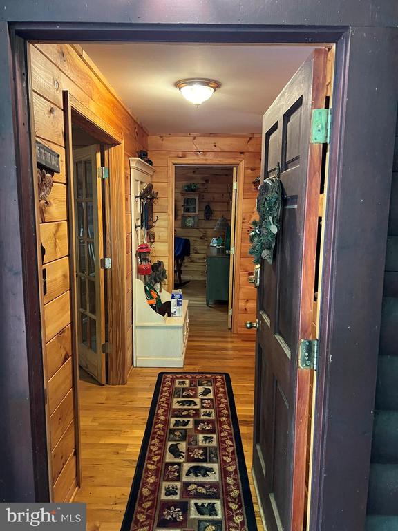 hall with wooden walls and light wood-type flooring