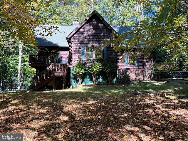 exterior space featuring a chimney, fence, log siding, stairs, and a wooden deck