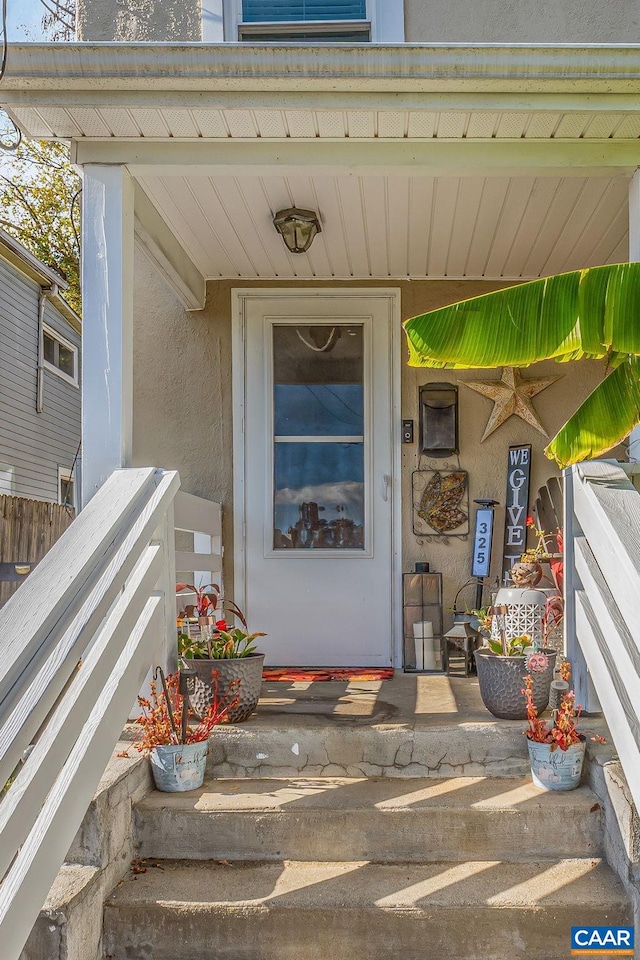 doorway to property featuring stucco siding