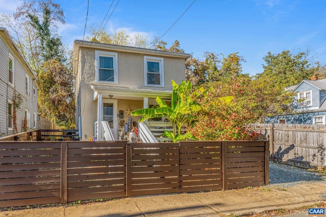 view of front of property with a fenced front yard and stucco siding