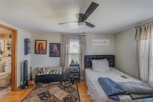 bedroom with ensuite bath, ceiling fan, and wood finished floors