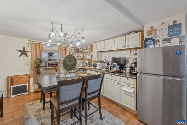325 10 1/2 St NW, Charlottesville, VA 22903 - kitchen with freestanding refrigerator, white microwave, light wood-style flooring, and dark countertops