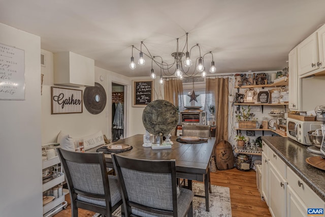 dining space with an inviting chandelier and light wood-style flooring
