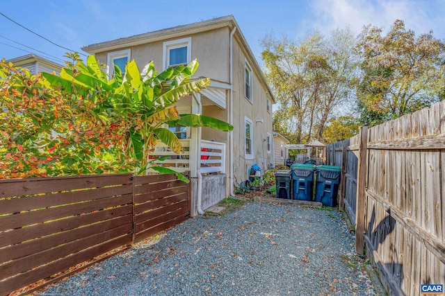 view of property exterior with stucco siding and a fenced backyard
