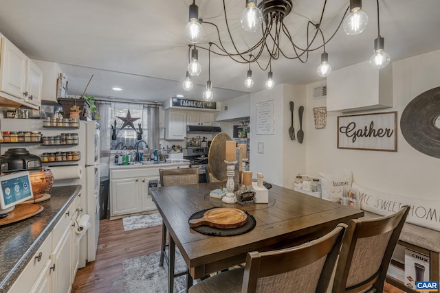dining room with dark wood finished floors, a chandelier, and visible vents