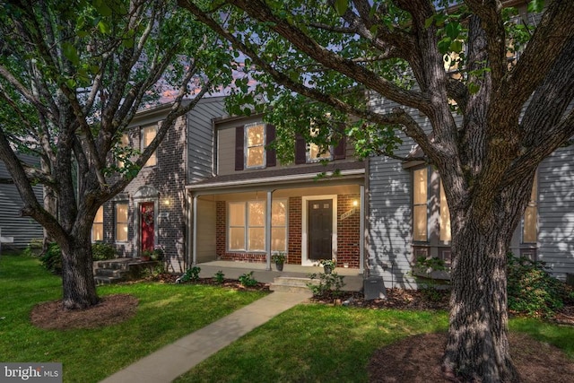 10718 Brice Ct, Fredericksburg, VA 22407 - view of front facade with a porch, brick siding, and a front lawn
