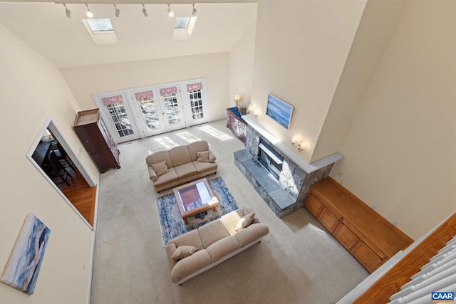 1972 Sclaters Ford Rd, Palmyra, VA 22963 - carpeted living area with a fireplace, high vaulted ceiling, a skylight, rail lighting, and french doors