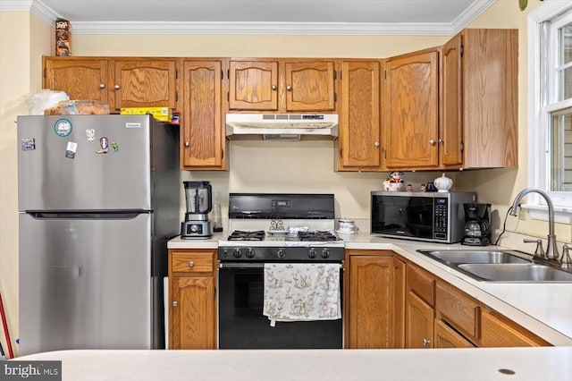 9814 Dominion Forest Cir, Fredericksburg, VA 22408 - kitchen with freestanding refrigerator, under cabinet range hood, range with gas stovetop, a sink, and light countertops