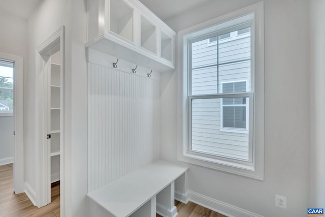 mudroom featuring light wood finished floors and baseboards