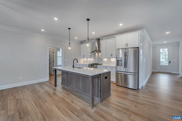 kitchen featuring wall chimney range hood, appliances with stainless steel finishes, light countertops, and crown molding