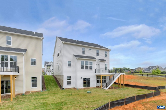 rear view of house featuring a yard, stairs, a wooden deck, and fence