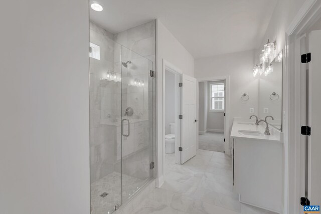 full bathroom with a stall shower, toilet, marble finish floor, a sink, and double vanity