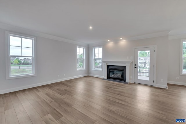 unfurnished living room featuring recessed lighting, crown molding, baseboards, a fireplace with flush hearth, and light wood-style floors