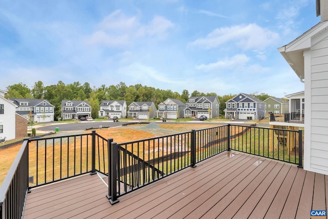 wooden terrace with a residential view and a lawn