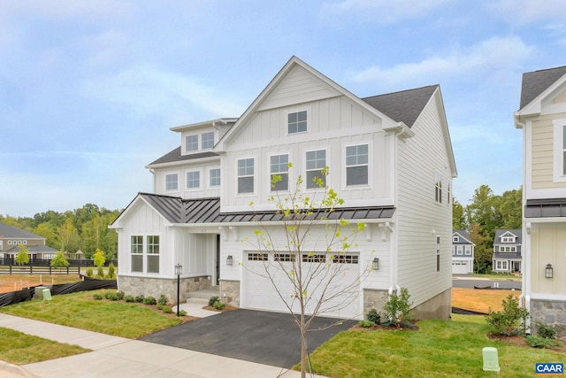 view of front of property with board and batten siding, a standing seam roof, an attached garage, and fence