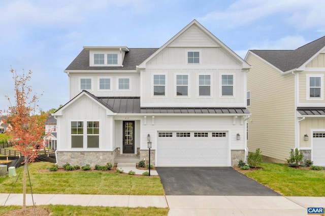 view of front facade with driveway, a standing seam roof, a garage, a shingled roof, and a front yard