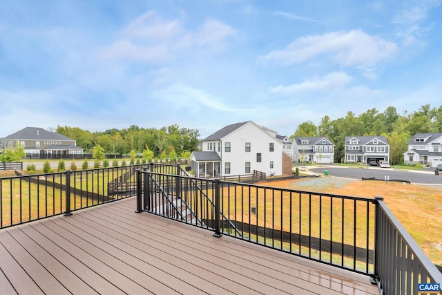 wooden deck featuring a residential view and a lawn