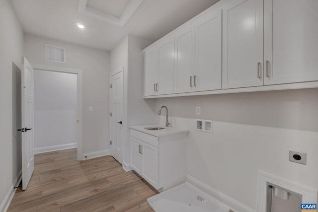 laundry area with hookup for a washing machine, visible vents, a sink, light wood-style floors, and electric dryer hookup