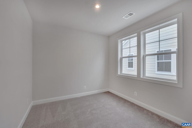 carpeted spare room with baseboards and visible vents