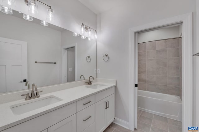 full bath featuring a sink, double vanity, baseboards, and tile patterned floors