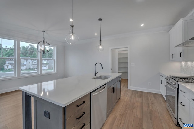kitchen featuring light wood finished floors, light countertops, a sink, range with gas stovetop, and dishwasher