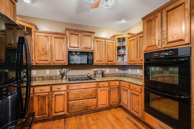 1763 Red Top Orchard Rd, Waynesboro, VA 22980 - kitchen featuring black appliances, brown cabinets, stone countertops, and light wood-style floors