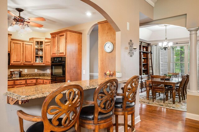 1763 Red Top Orchard Rd, Waynesboro, VA 22980 - kitchen with arched walkways, a breakfast bar, ceiling fan, light stone counters, and ornamental molding
