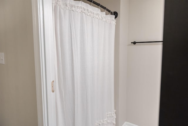 bathroom featuring a shower with curtain and baseboards
