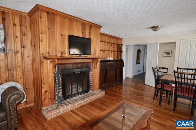 living area featuring a brick fireplace and wood finished floors