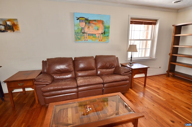 living room with visible vents, baseboards, ornamental molding, and hardwood / wood-style flooring