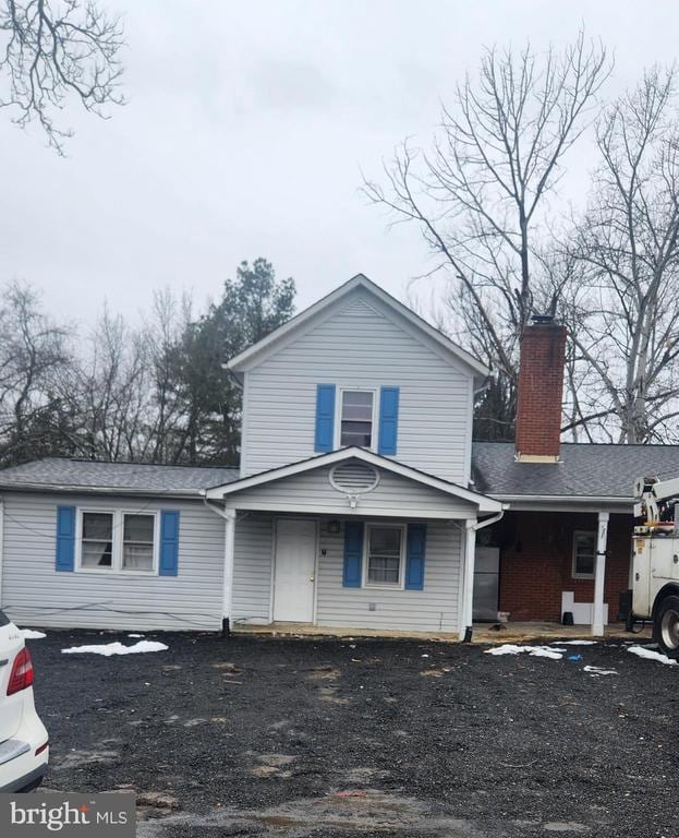 view of front of house with covered porch and a chimney