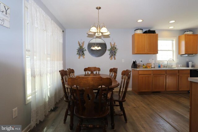 dining room with sink, dark wood-type flooring, and a chandelier