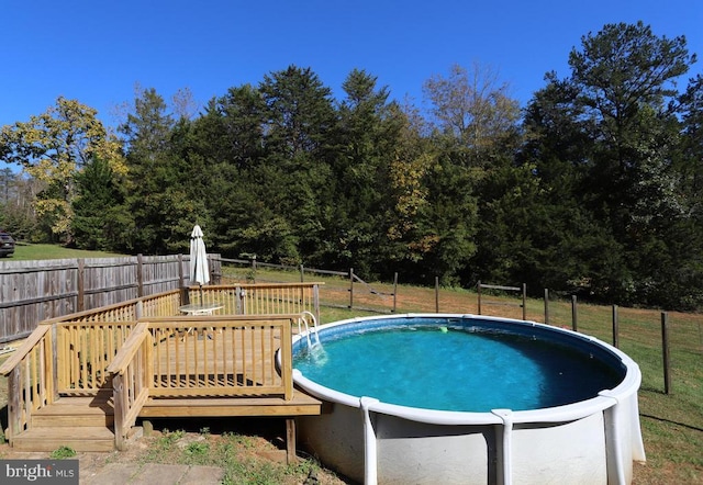 view of swimming pool featuring a wooden deck and a yard